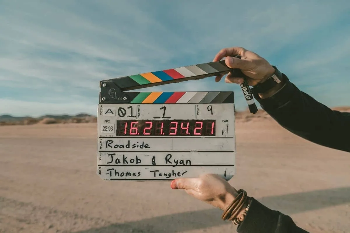 Close-up of clapperboard used on film set, with desert landscape background for TV production.