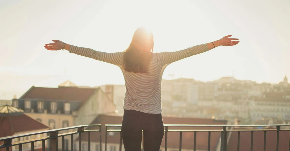 Women celebrating freedom and joy on a balcony during sunrise or sunset.