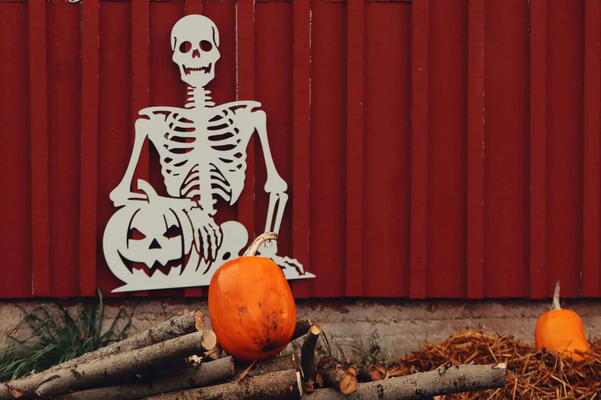 Skull and skeleton wall decor with pumpkins, perfect for Halloween ambiance.