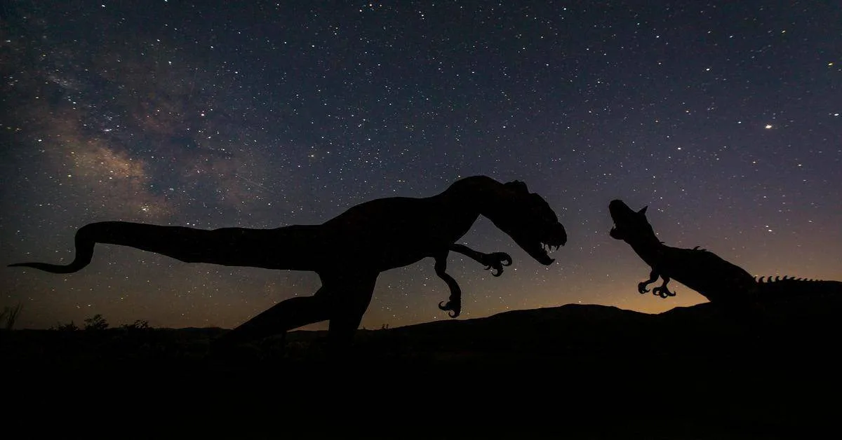 Dinosaur silhouettes against a starry night sky with Milky Way, depicting prehistoric wildlife scene.