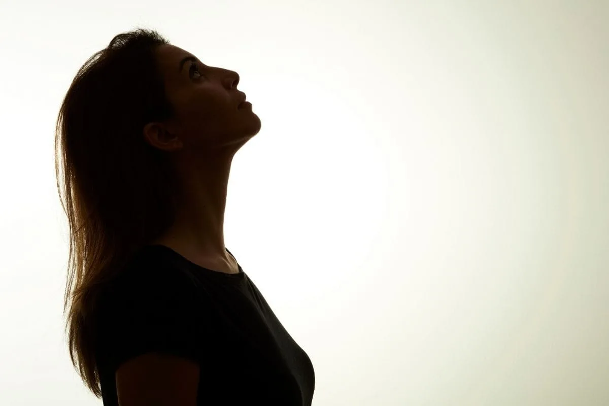 Dramatic silhouette profile of a woman with long hair looking upward against a bright white backlit background, evoking the mysterious and supernatural tone of shows like Lost Girl and Manifest