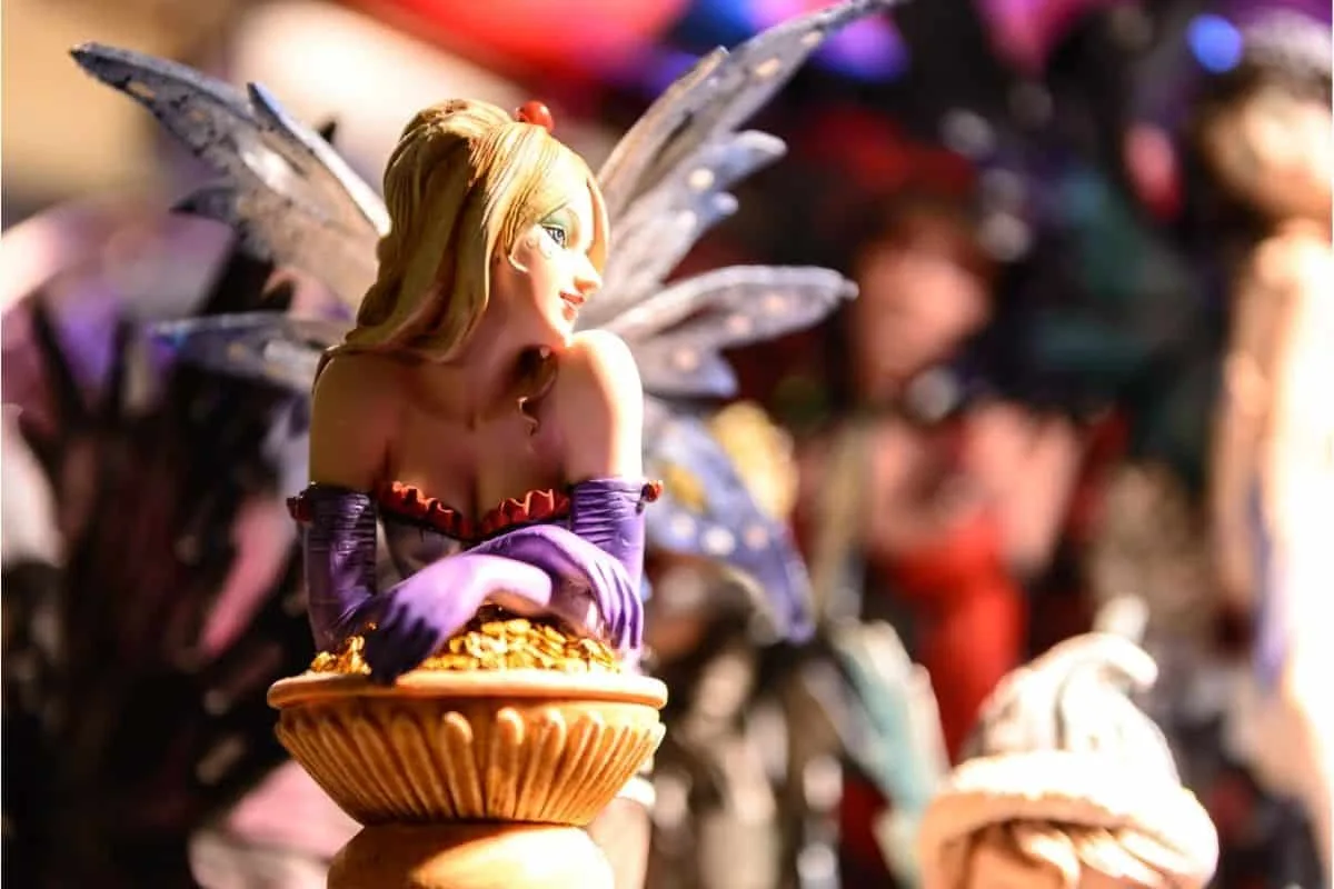 Detailed fairy sculpture with spread wings, costume, and basket of gold coins representing movies about fairies